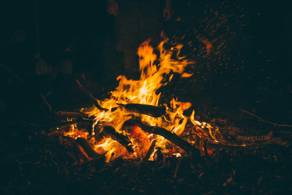 Ein Lagerfeuer brennt in dunkler Nacht.